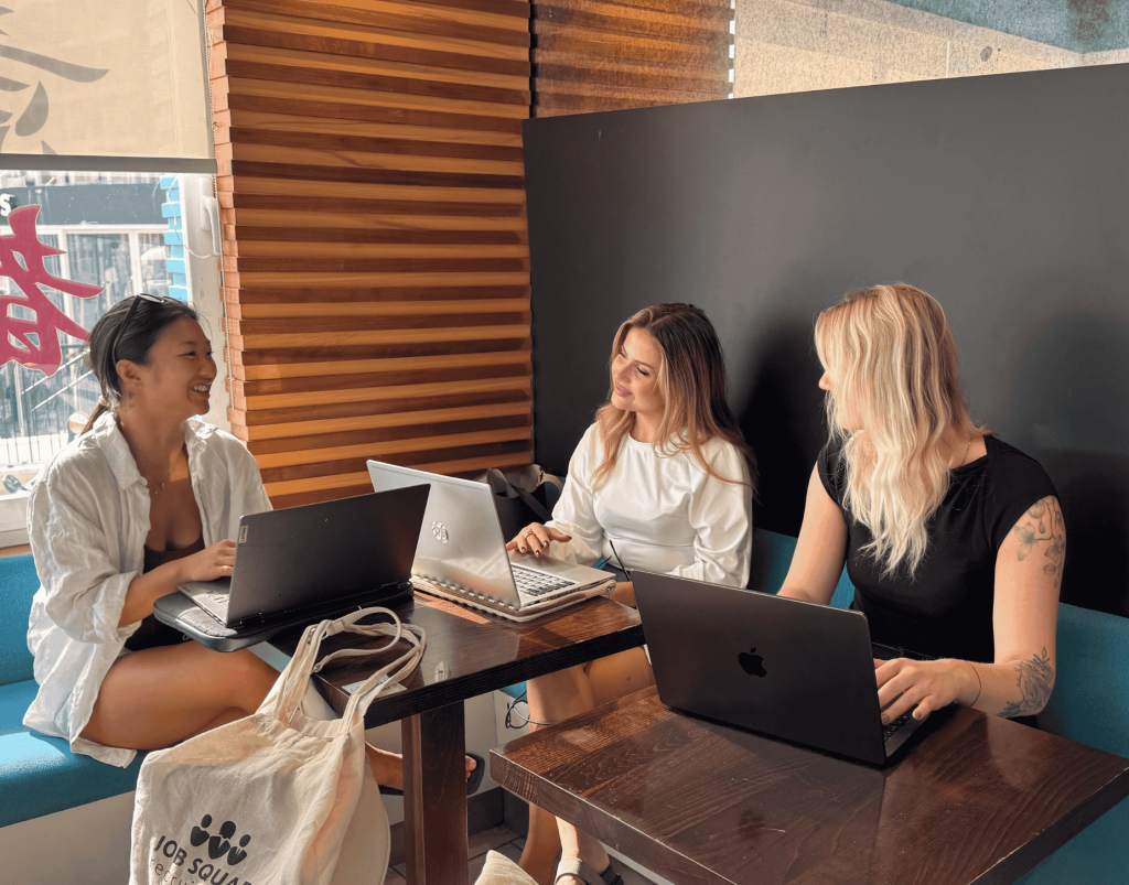 A job squad customer support agent sitting at a modern desk with dual monitors, answering questions from job seekers.