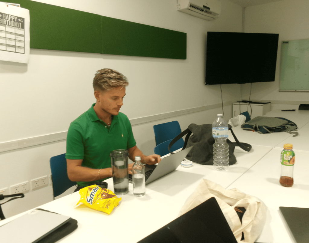 Two job squad team members collaborating over a laptop, reviewing applications and matching candidates to international roles.