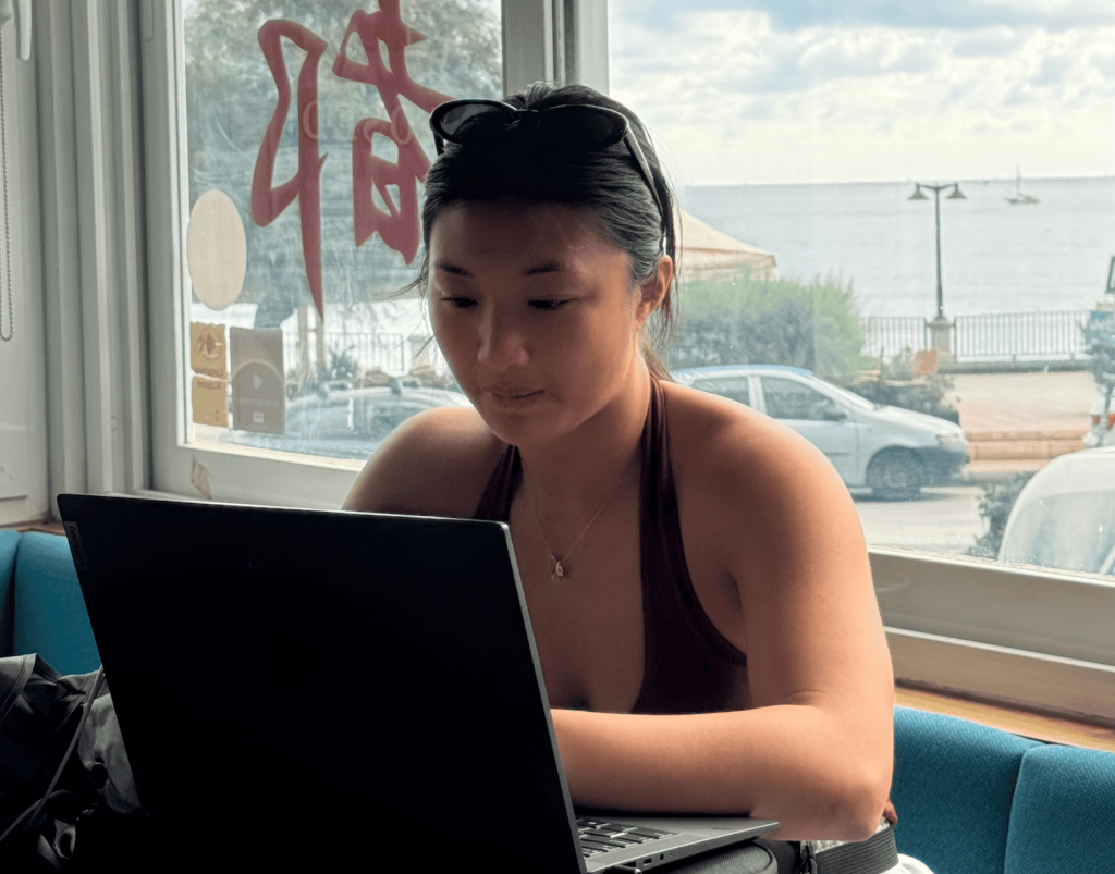 A recruiter in a bright office helping a young job seeker through an online interview, with sticky notes and motivational posters in the background.