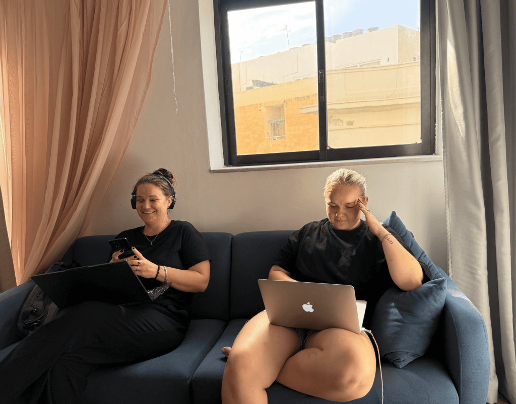 A cheerful job squad recruiter wearing a headset, smiling while talking to a candidate on a video call, helping them find a job abroad.