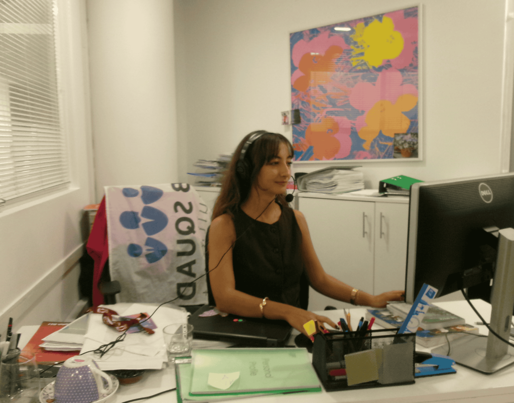 Ystävällinen rekrytoija juhlii onnistuneesti ehdokkaan sijoittamista unelmatyöhön ulkomailla, hymyillen kahvikupin kanssa.