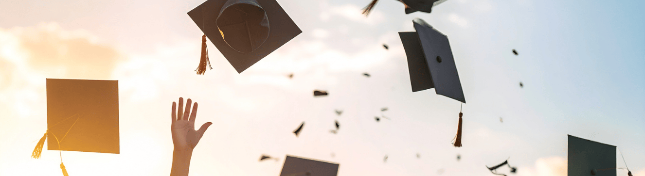 Graduates celebrating with thrown caps.