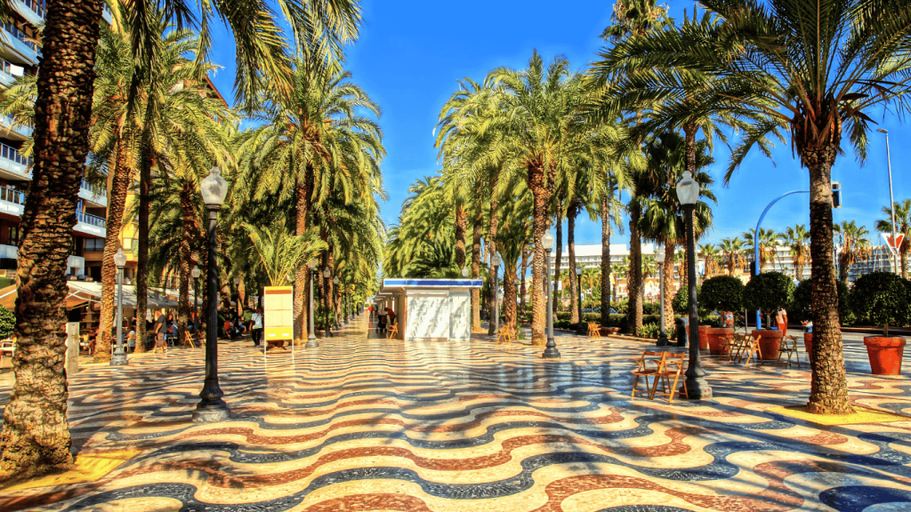 Palm-lined promenade with vibrant tiles in Alicante; working in Spain